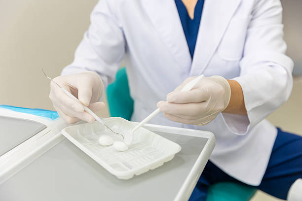 Dentist holding alcohol cotton ball and preparing to examine the teeth of female patient