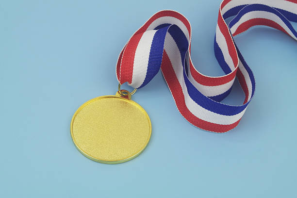 istock Gold medal with ribbon on blue 2233783416