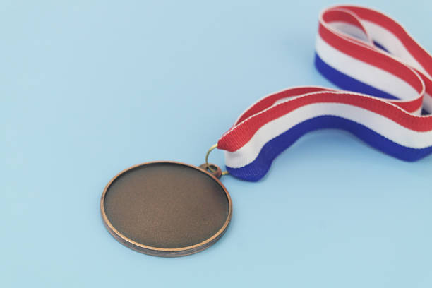 Bronze medal with ribbon on blue background
