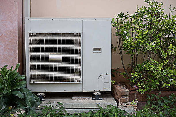 istock Install an air conditioner compressor in the building. Outdoor Split Type Air Conditioner Compressor Unit Inverter installed outside the building Air conditioning compressor at the garden 2233794575