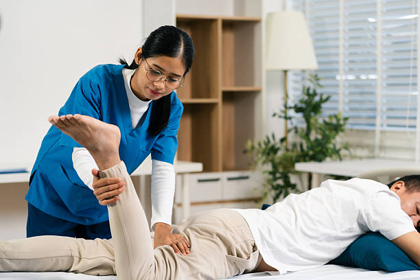 istock senior man doing exercise at clinic with physiotherapist. help of a personal trainer during a rehabilitation session. 2233794602