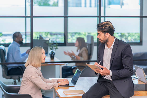 istock young businessman using tablet computer,having discussion with asian business woman at work desk,employees company working in the office room 2233794611