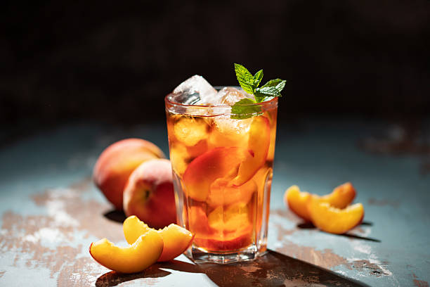 istock Peaches iced tea  in a glass on the table. Summer drink concept 2233796294