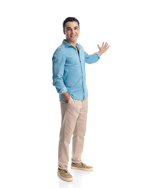 istock proud casual man with hand in pocket inviting to side while smiling 2233796911