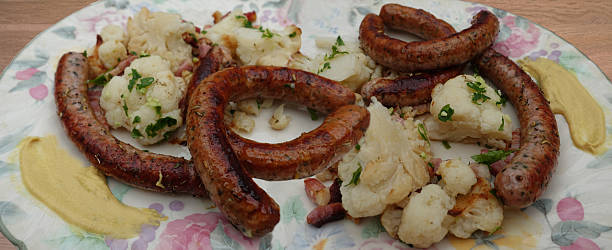 Fried chipolata served with cauliflower and bacon