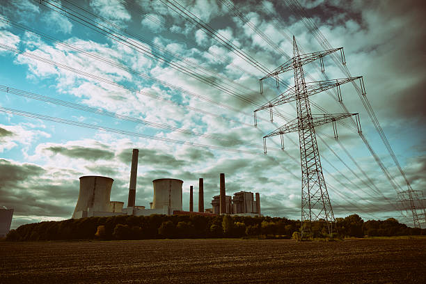 Brown-coal burning power plant out of service beside a group of electricity pylons.
