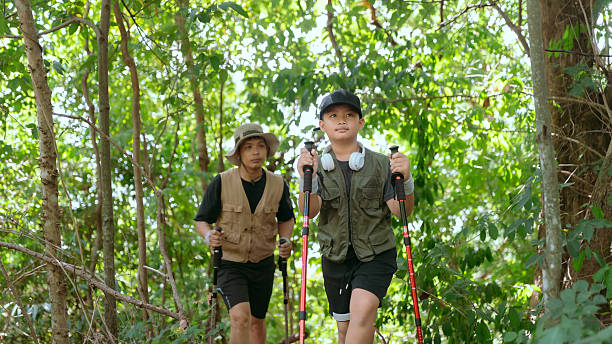 istock Two hikers explore a lush green forest trail during a sunny day in nature while enjoying a conversation about their adventure 2233801279