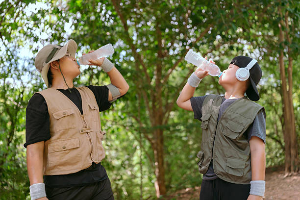 istock Two young boys celebrating with water bottles while hiking in a forest during a sunny afternoon 2233801342