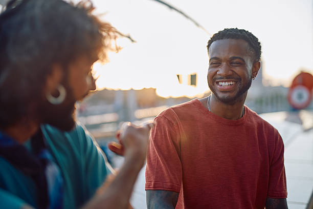 istock Two young men talking and laughing at sunset 2233801452