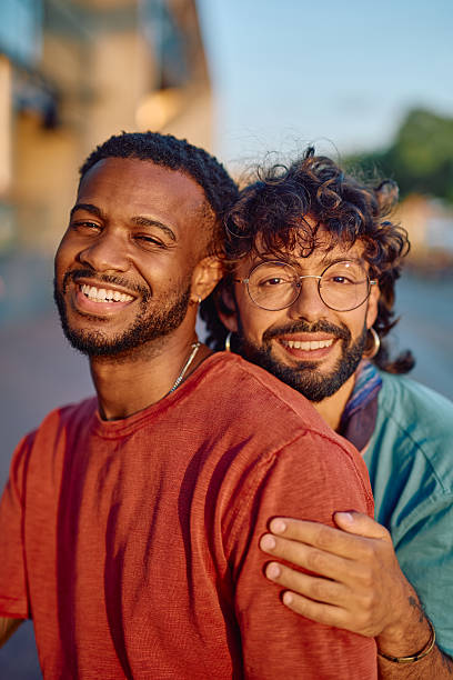 istock Two young men embracing and smiling at camera 2233801462