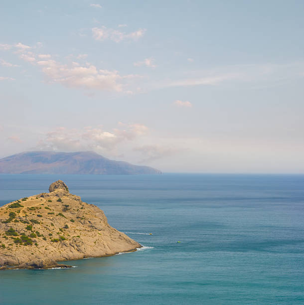Rocky mountain sea coast with cloudy sky, old volcano Karadag, Crimea.