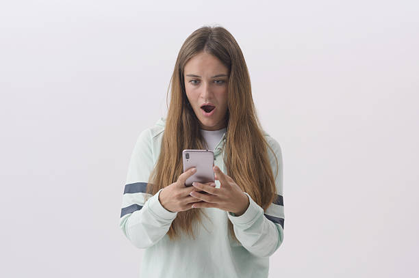 istock Shocked woman using her smartphone 2233804426