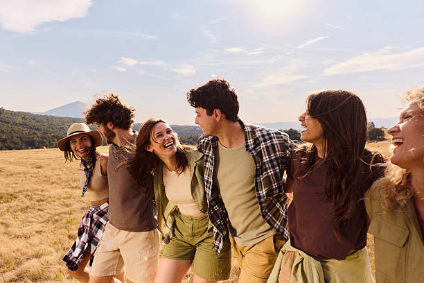 istock Happy friends talking while walking embraced in nature. 2233805787