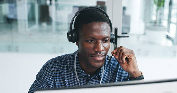 istock Black man, reading and computer with mic at call centre for customer service, client inquiry and crm. Male agent, headset and pc for helping, telecom faq and information survey of feedback procedure 2233807663