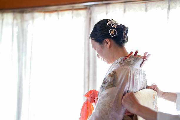 istock A woman is getting ready for a wedding, and a woman is helping her 2233808936