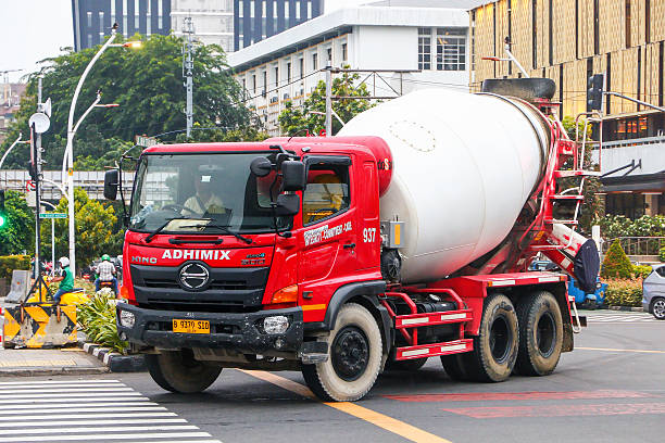 Jakarta, Indonesia - February 16, 2025: Red industrial concrete mixer truck Hino 500 Series Jumbo Ranger in the city street.