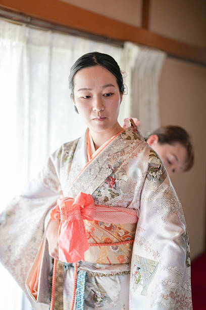 istock A woman in a kimono is adjusting her sash 2233809913