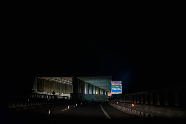 Illuminated tunnel on the highway at night. Toll road