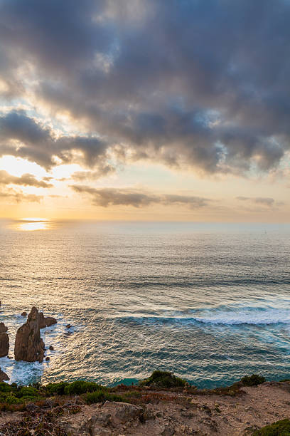 istock A dramatic coastal scene with towering sea stacks, rugged cliffs, and lush greenery under a golden-hued sky 2233810715