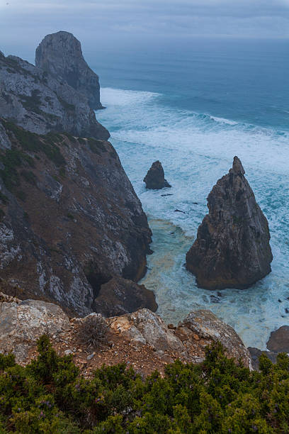 istock A dramatic coastal view with jagged sea stacks rising from turbulent waters, framed by steep cliffs and lush greenery 2233812779