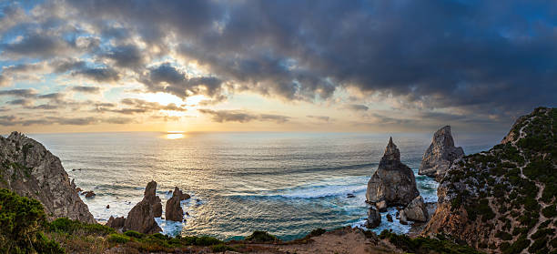 istock rugged cliffs, and golden light reflecting on the ocean under a moody sky 2233812856