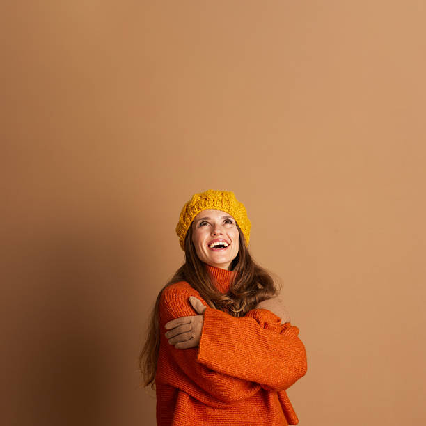 istock Smiling Woman in Yellow Beret Hugging Herself 2233813631