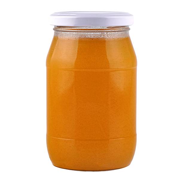 istock Glass jar with orange liquid isolated on white. 2233816170