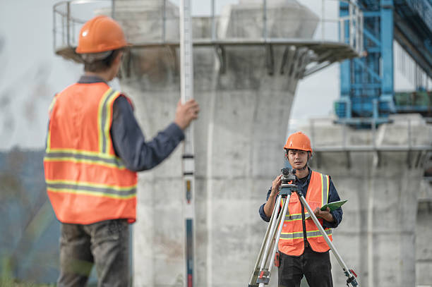 istock Survey technical checking level of site construction with leveling camera digital.  Survey Team Using Leveling Instrument at Elevated High-Speed Railway Construction Site 2233818763