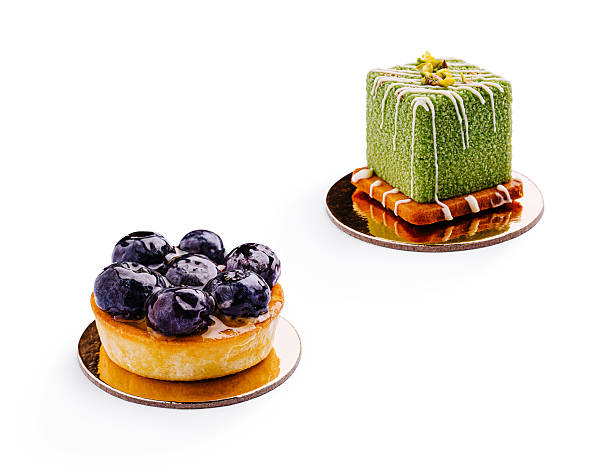 Delightful desserts featuring blueberries and matcha cake on a white background