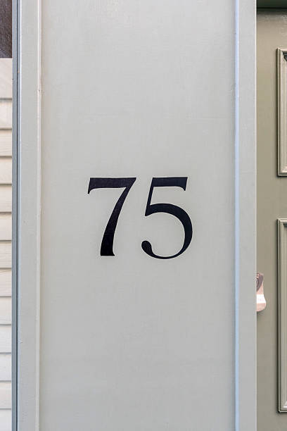 istock Black painted number seventy five by doorway 2233818864