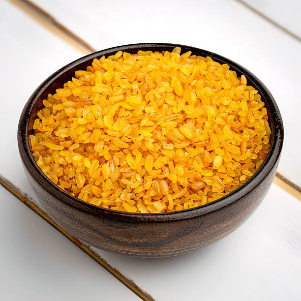 istock Wooden bowl with golden bulgur wheat. 2233819001