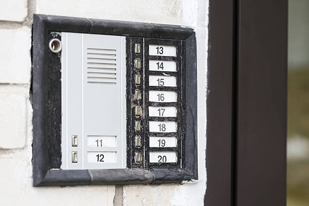 istock Apartment intercom panel with multiple buttons on the wall near entrance door. Old style metal doorbell with numbered keys for residents. 2233822576
