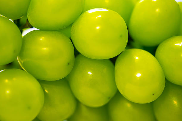 One green bunch of grapes isolated on a white background. High angle view, studio shot.