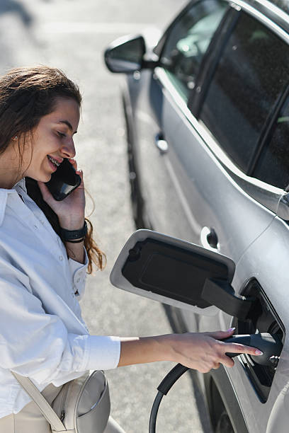 istock Joyful Woman Charging Her EV While Having Friendly Phone Conversation 2233823091