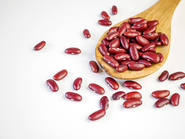 istock Red bean seeds on a wooden spoon on a white background 2233824328