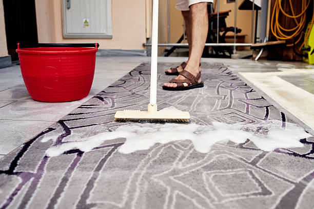 istock Man Cleaning a Rug with a Brush and Soapy Water 2233824885