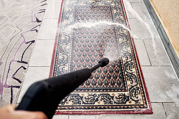 Man using chemical spray to remove stain from carpet in carpet cleaning service