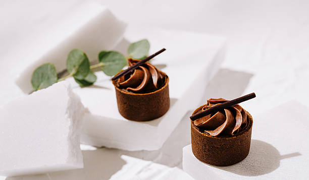 Delicious chocolate mousse cups on elegant display with greenery accents