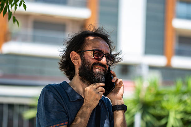 A Man Talking On A Mobile Phone In An Open Area