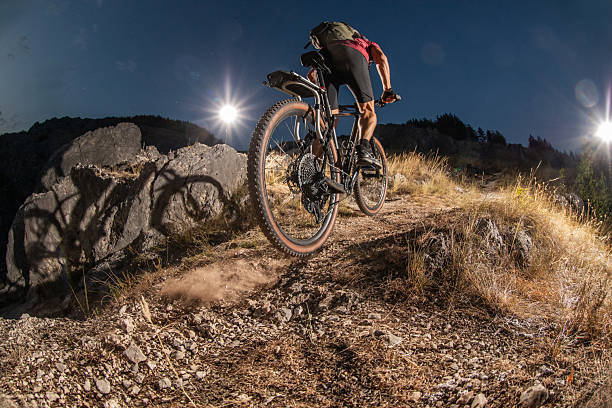 istock Mountain Cyclist Riding at Night on a Trail Under Bright Light 2233829088