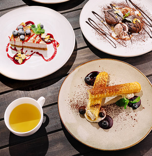 Delicious dessert assortment displayed on a rustic wooden table in bright light