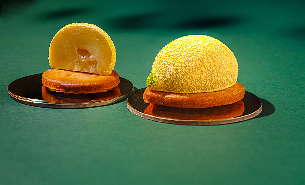 Unique mousse dessert creations shaped like fruits on display under soft lighting