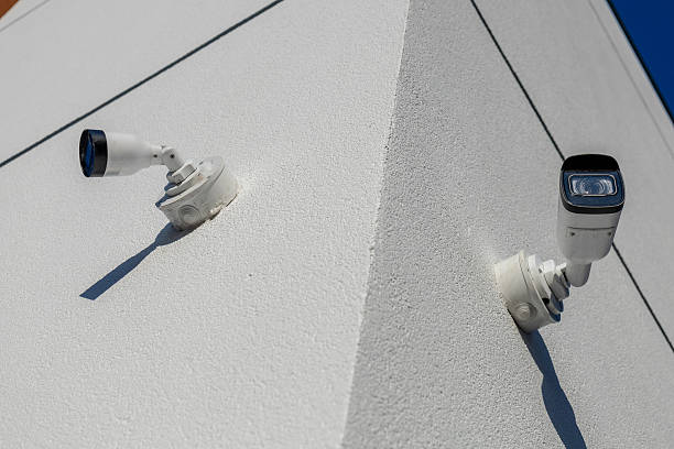 istock Two security cameras are mounted on the corner of a building, providing surveillance coverage in a bright environment with a clear sky 2233836729