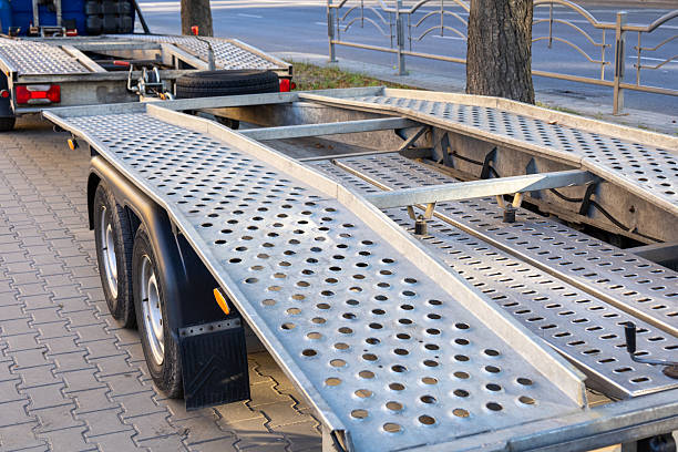 istock A trailer with a metallic surface is parked on a tree-lined street in the early morning light, emphasizing its functional design and construction 2233836780