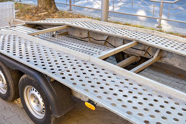 istock A trailer featuring a perforated steel surface rests on a paved area near a pedestrian walkway under clear blue skies 2233836783