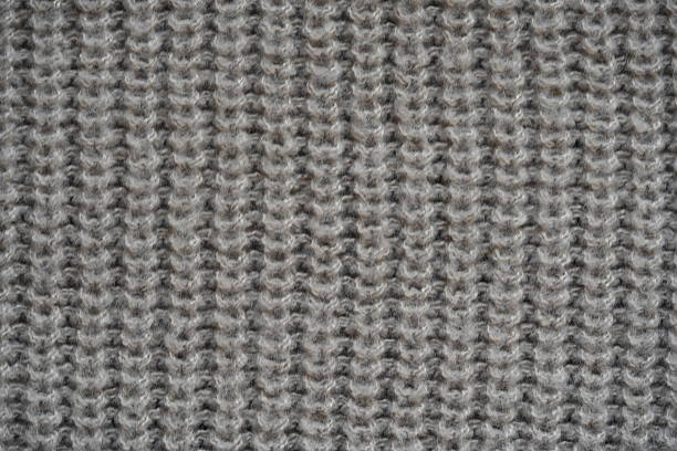 Jersey textile background , yellow striped knitted fabric. Woolen knitwear, sweater, pullover surface texture, textile structure, cloth surface, weaving of knitwear material. Wallpaper, backdrop.