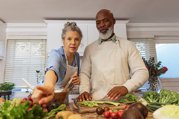 istock Mature Couple Reading Recipe from Invisible Screen – Kitchen Scene 2233837632