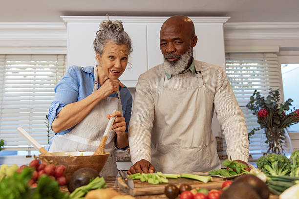 istock Mature Couple Reading Recipe from Invisible Screen – Kitchen Scene 2233837638