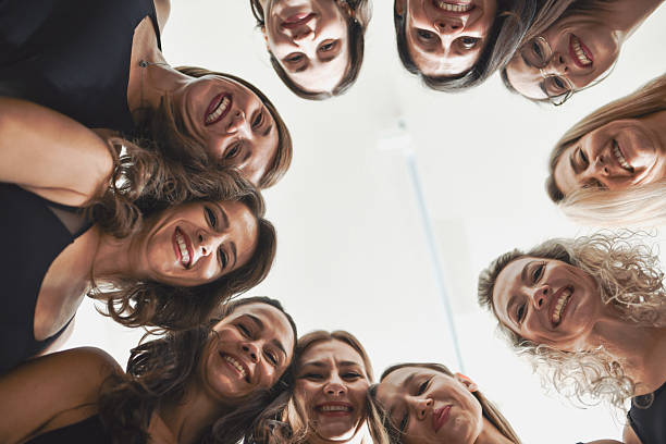 istock Joyful Diverse Women Shot From Below Smiling At Camera While Forming Perfect Circle 2233838015