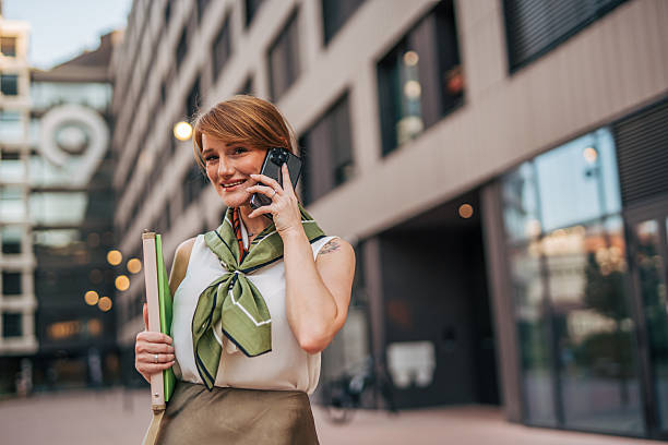 istock Businesswoman smiling while talking on phone in urban setting 2233838210